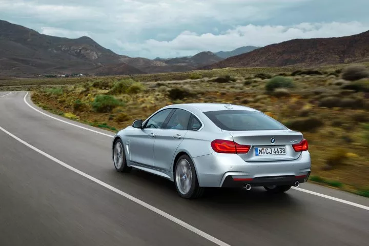 Vista dinámica del BMW Serie 4 en carretera mostrando su perfil elegante y deportivo.