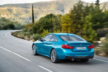 Vista dinámica del BMW Serie 4, destacando su línea trasera y lateral en movimiento.