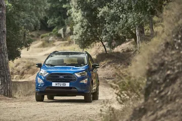 Vista delantera y lateral del Ford EcoSport en un camino forestal.