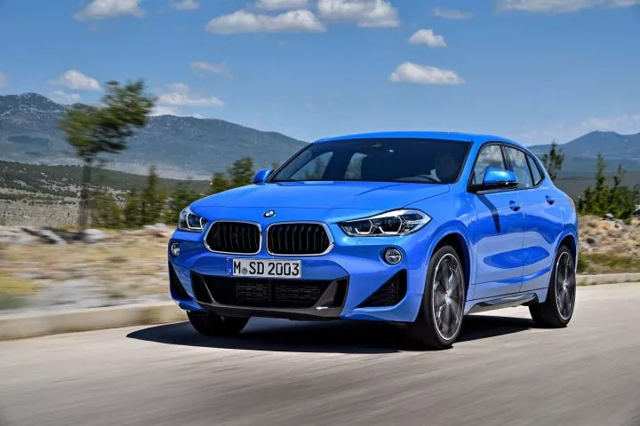 Vista dinámica del BMW X2 en azul mostrando su perfil delantero y lateral.