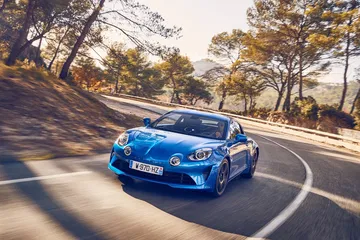 Vista dinámica del Alpine A110 negociando una curva con agilidad.
