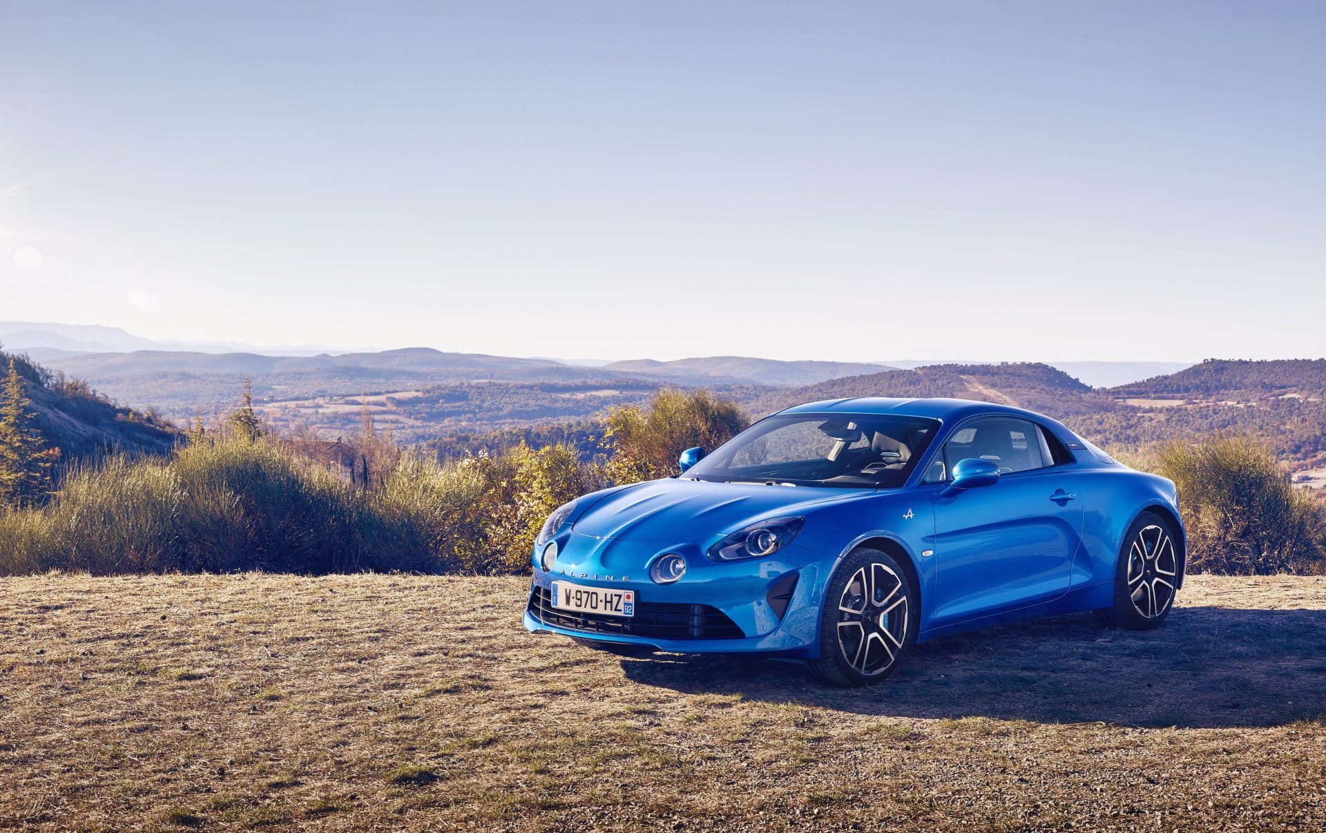 Vista lateral y frontal del Alpine A110 en un entorno natural.
