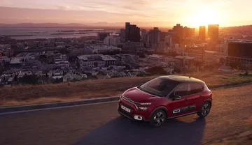 Vista lateral del Citroën C3 con puesta de sol de fondo