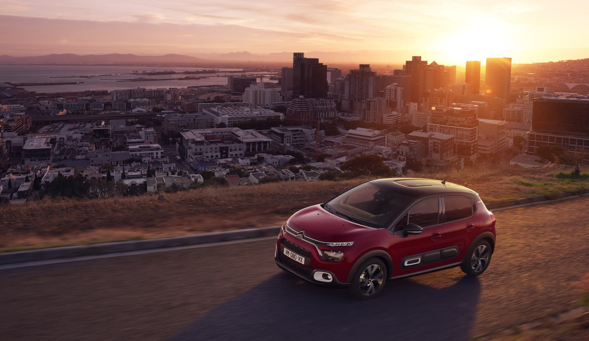 Vista lateral del Citroën C3 con puesta de sol de fondo