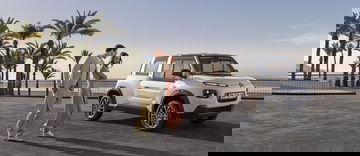 Vista lateral del Citroën e-Mehari junto a la playa con una pareja al lado.
