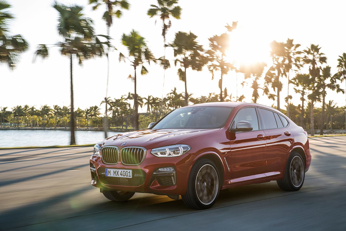 BMW X4 en movimiento bajo una luz de atardecer que realza su diseño.