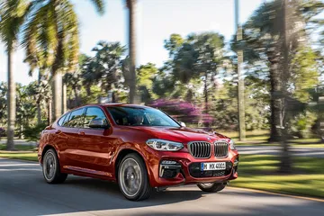 BMW X4 en movimiento mostrando su dinámica delantera y línea lateral