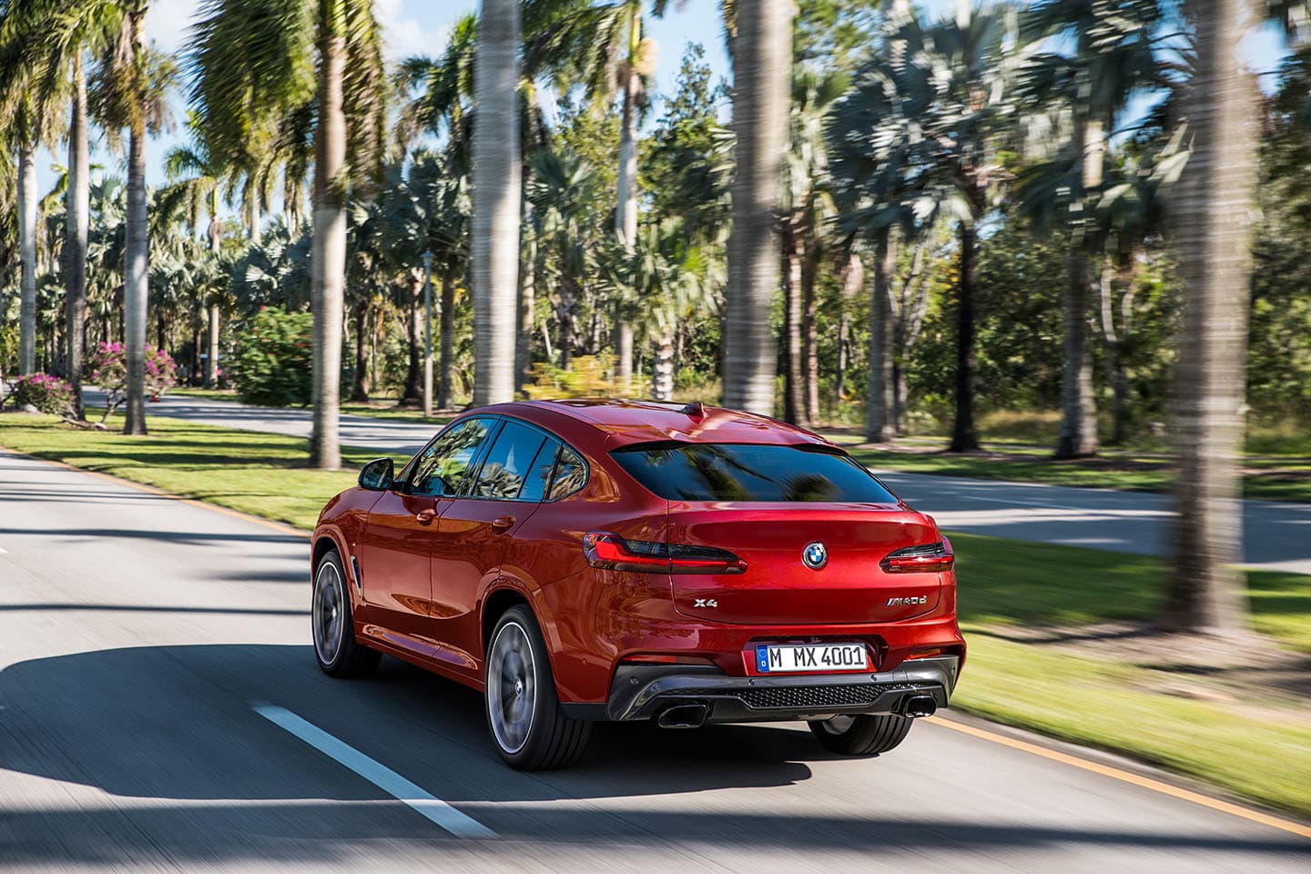 Vista dinámica del BMW X4 mostrando su diseño trasero y perfil lateral en movimiento.