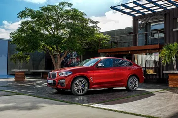 Vista lateral del BMW X4 en un entorno urbano destacando su dinámico diseño.