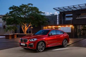Vista lateral del BMW X4 destacando su línea dinámica y coupé.