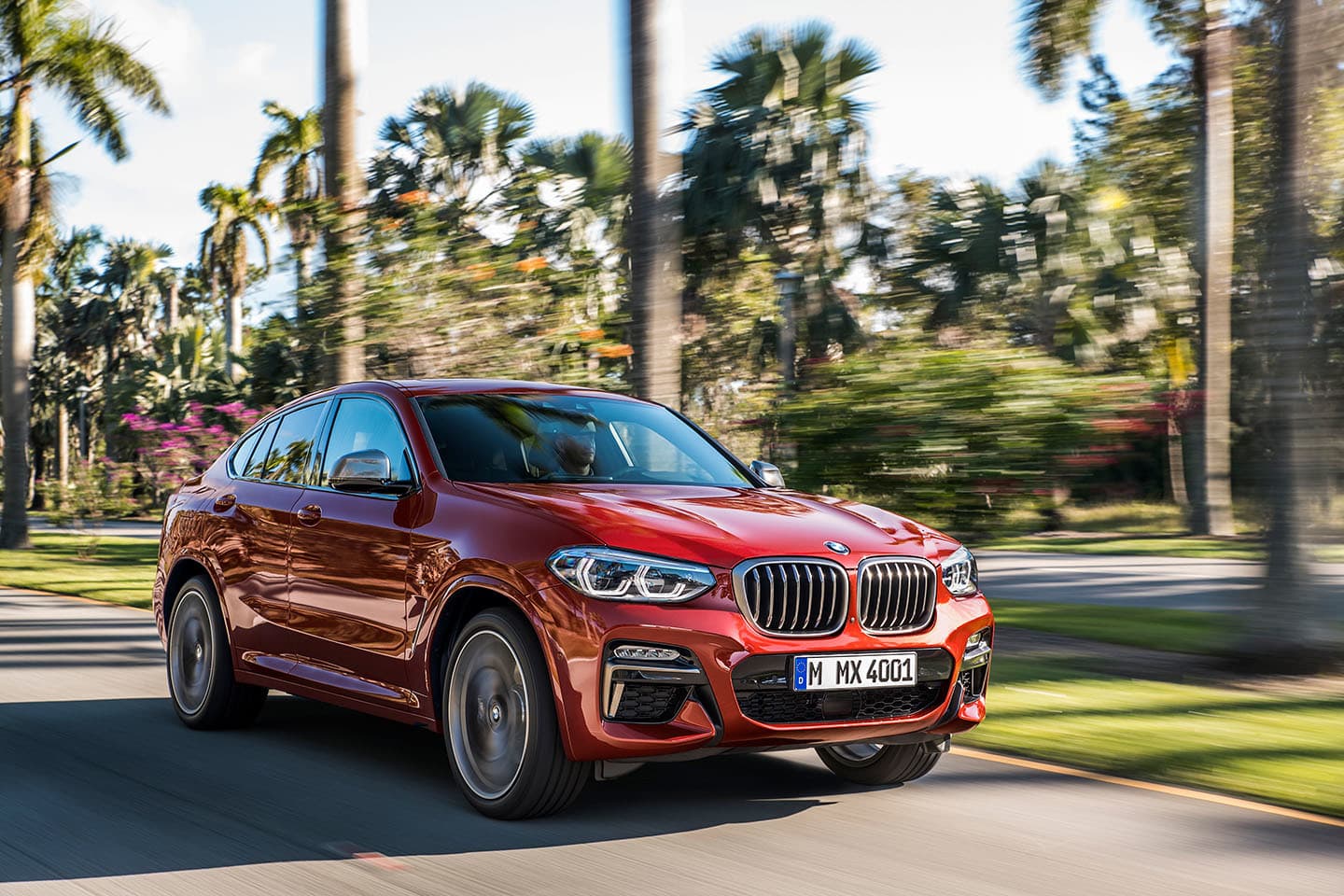 Vista dinámica del BMW X4 en movimiento mostrando su frontal y perfil.