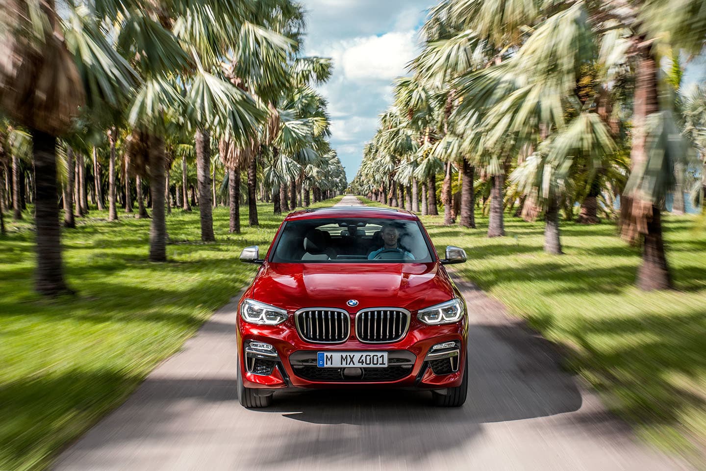 Vista frontal del BMW X4 en movimiento, destacando su diseño deportivo.