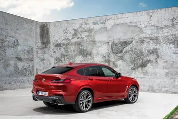 Vista lateral trasera del BMW X4, mostrando su diseño aerodinámico y deportivo.