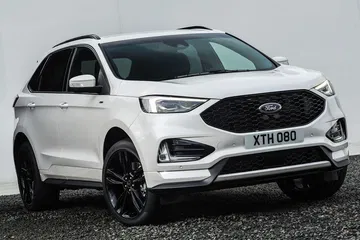Vista frontal y lateral del Ford Edge, destacando su robusta parrilla y faros modernos.