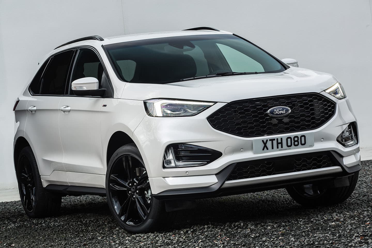 Vista frontal y lateral del Ford Edge, destacando su robusta parrilla y faros modernos.