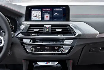 Vista del sistema de infotainment BMW X4 con pantalla táctil y controles.