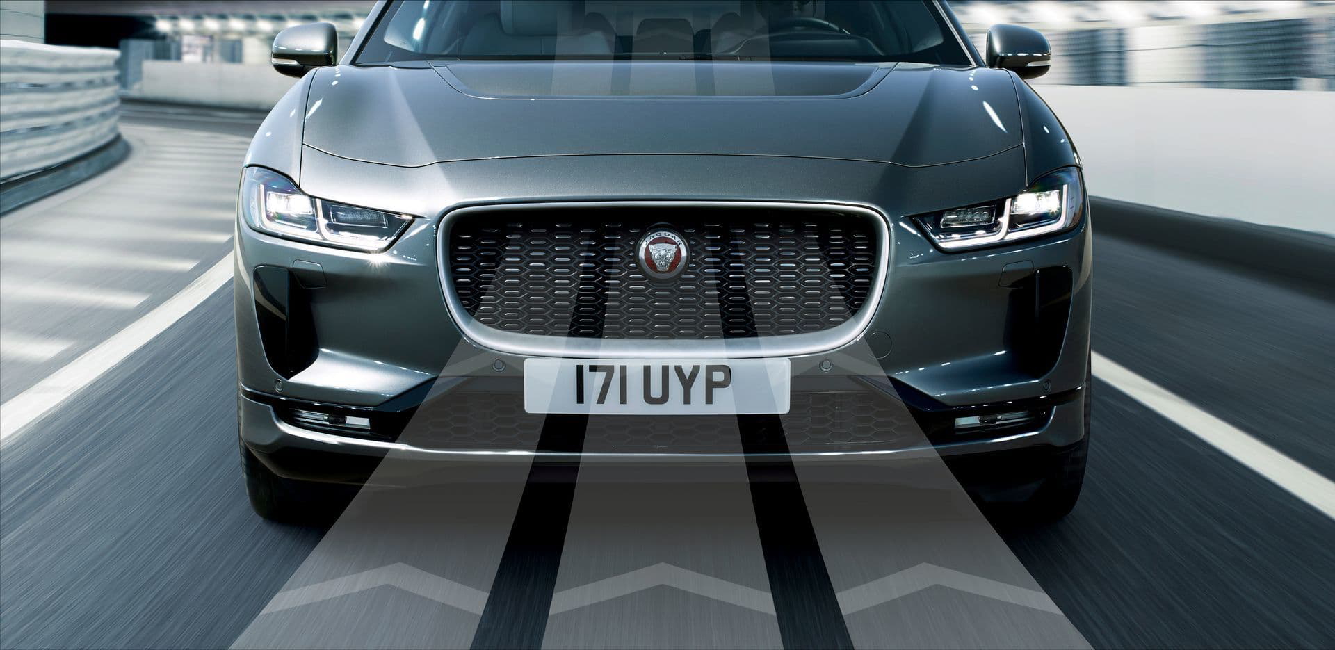 Vista lateral del Jaguar I-PACE rodando con el océano de fondo