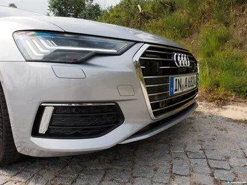 Vista dinámica frontal del Audi A6, destacando su parrilla y faros.