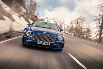 Vista frontal del Bentley Continental GT en acción, destacando su imponente parrilla.
