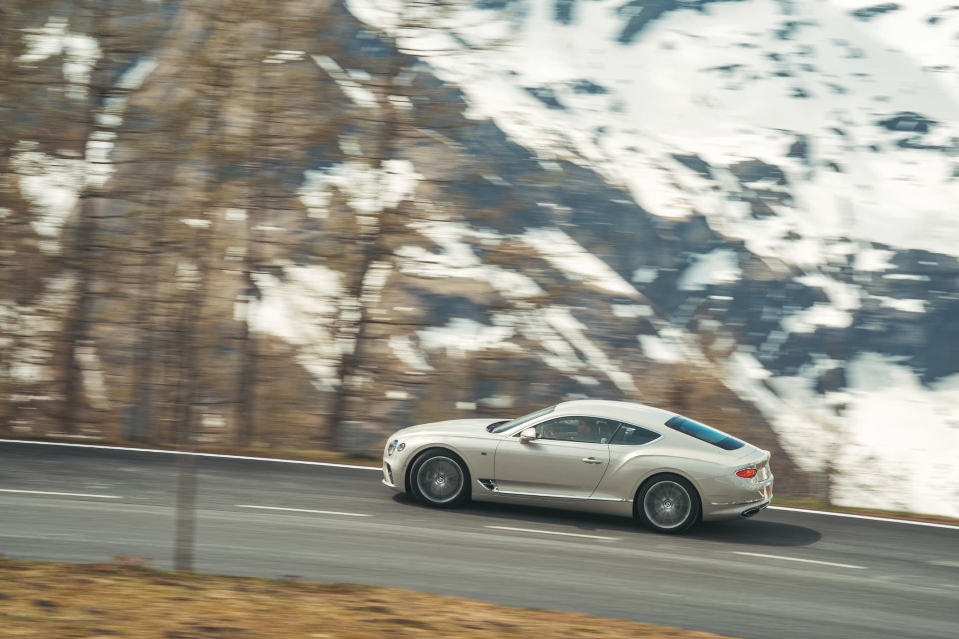 El Bentley Continental GT muestra su perfil lateral en un entorno montañoso.