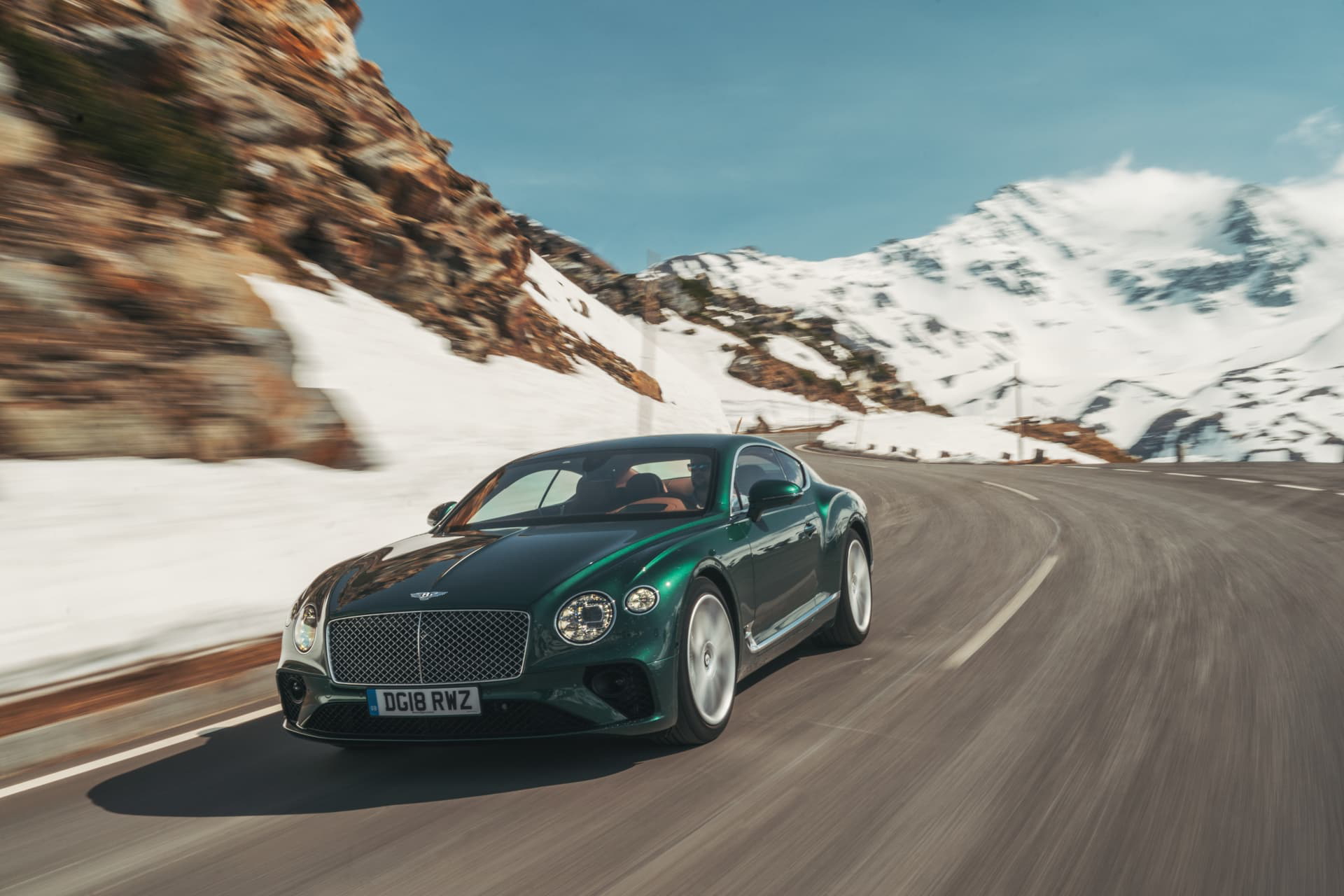 Vista dinámica del Bentley Continental GT en carretera invernal.