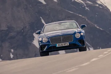 Vista dinámica del Bentley Continental GT en carretera de montaña