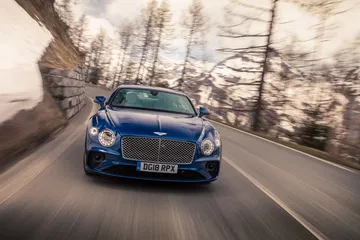 Vista dinámica del Bentley Continental GT en carretera, enfatizando su diseño elegante.