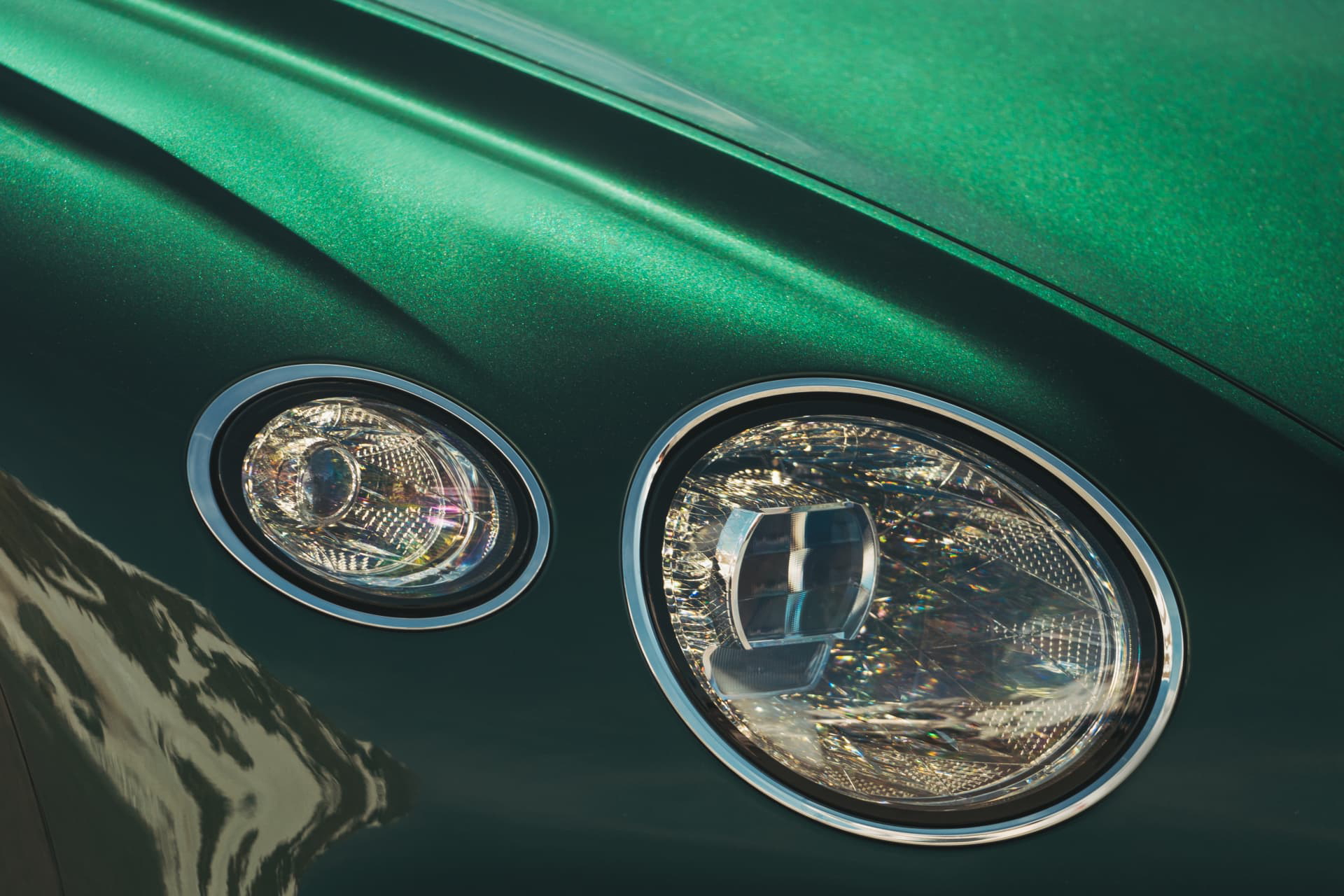 Vista cercana de los faros del Bentley Continental GT, mostrando su diseño distintivo.