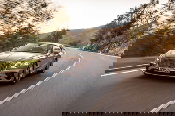 Vista lateral del Bentley Continental GT en un paisaje montañoso.