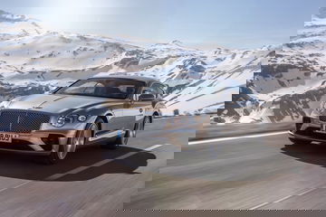 Vista dinámica del Bentley Continental GT con paisaje montañoso de fondo