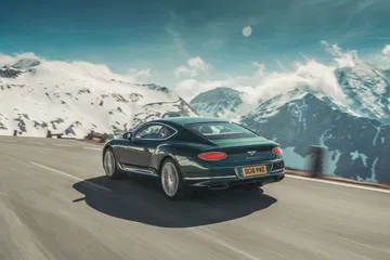 Bentley Continental GT mostrando su silueta trasera y lateral en un paisaje montañoso