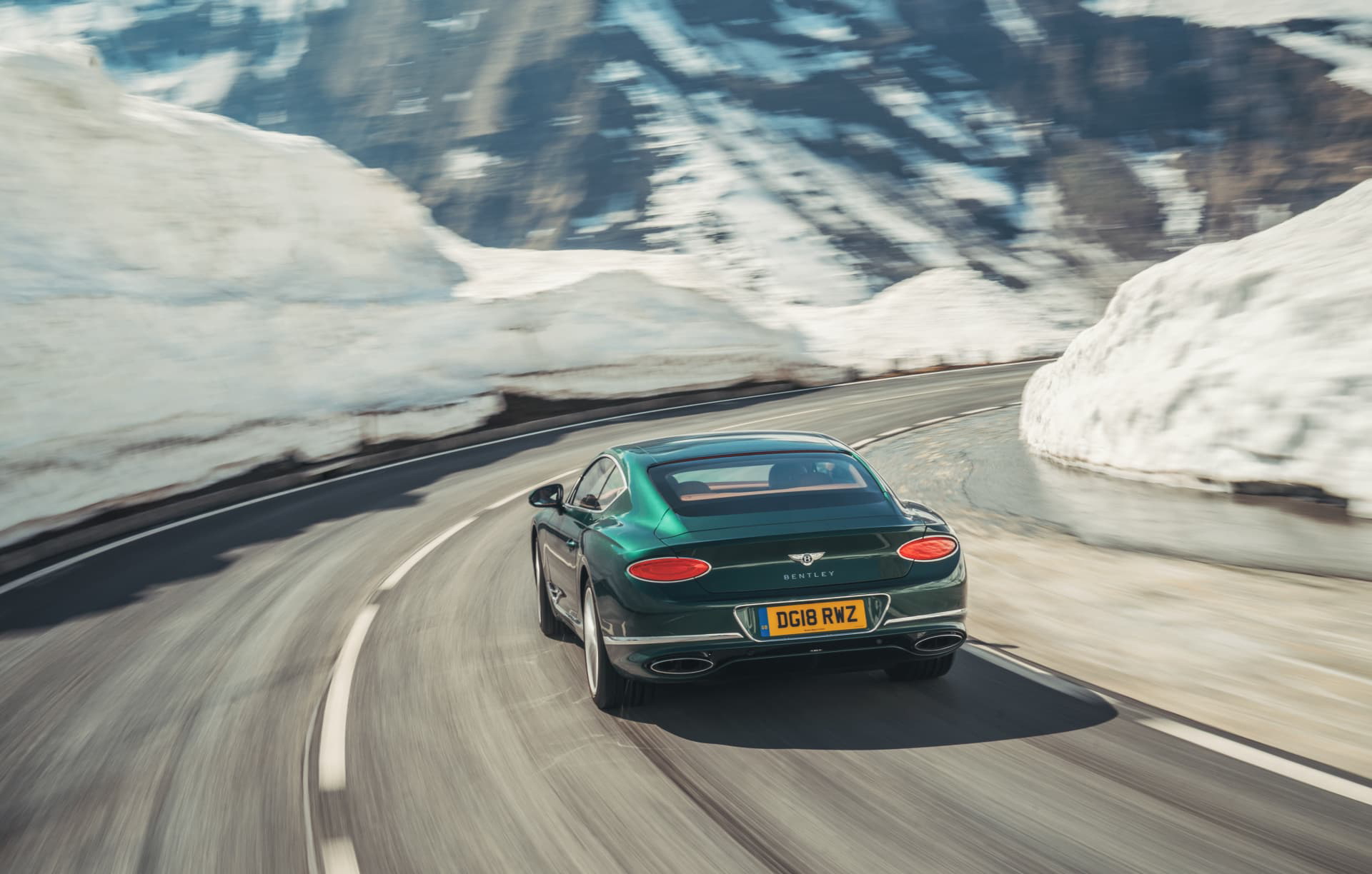 Vista dinámica del Bentley Continental GT rodando en carretera nevada.