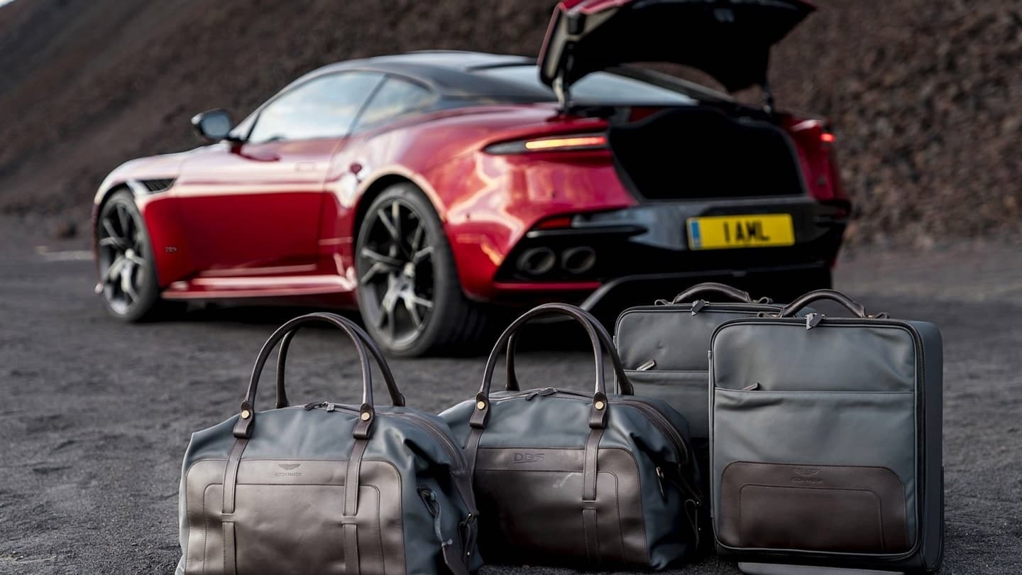 Vista trasera y lateral del DBS Superleggera con maletero abierto y equipaje.