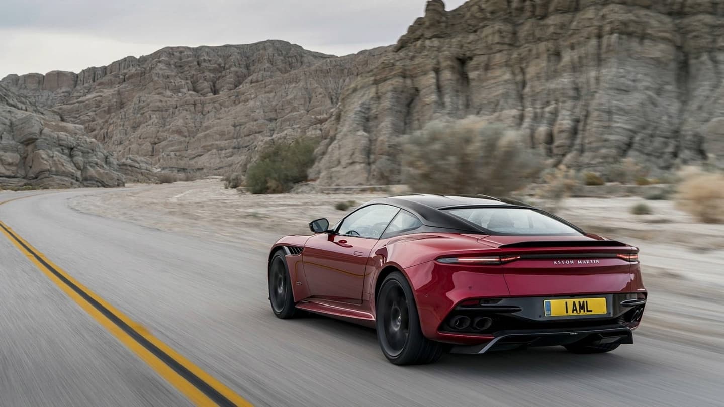La trasera y lateral del DBS Superleggera destacan mientras recorre una carretera de montaña.