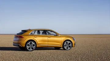 Vista lateral Audi Q8 destacando su dinámico perfil y diseño de llantas.