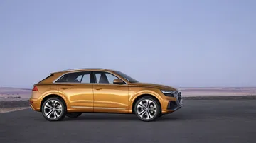 Perfil lateral del Audi Q8 mostrando su diseño aerodinámico y llantas.