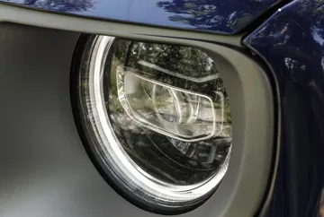 Vista cercana del faro delantero redondo del Jeep Renegade, destacando su diseño icónico.