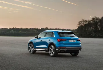 Perfil dinámico y elegante del Audi Q3, destacando su línea de techo y llantas.