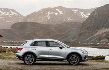 Perfil del Audi Q3 con diseño robusto y elegante ante paisaje montañoso.