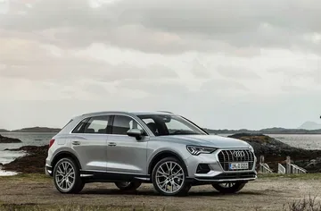 Vista lateral del Audi Q3 en movimiento mostrando el perfil y llantas.