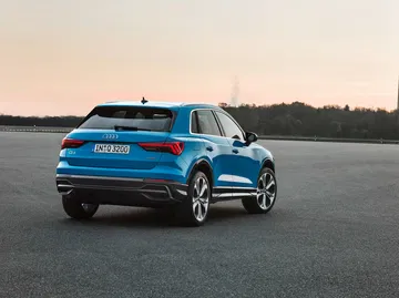 Vista dinámica trasera y lateral del Audi Q3 destacando su diseño deportivo.