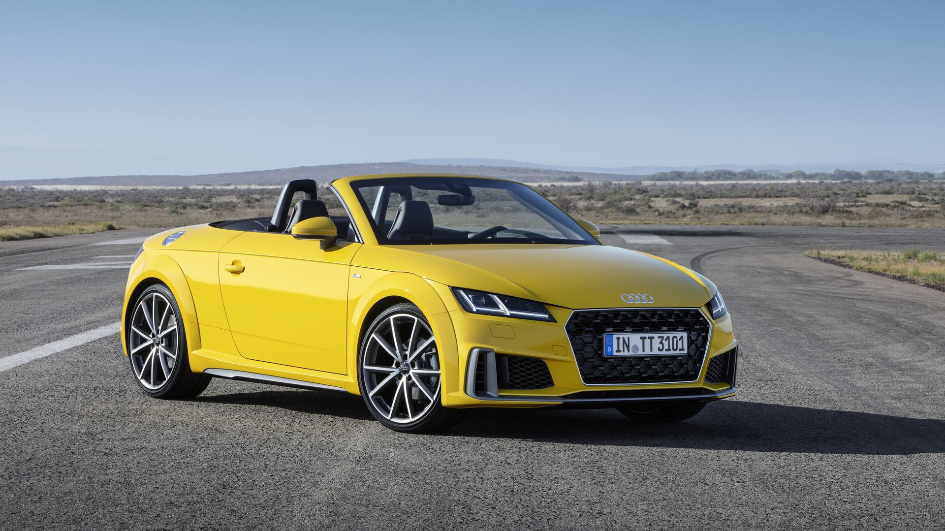 Vista lateral delantera del Audi TT Cabriolet en un acabado amarillo vibrante.