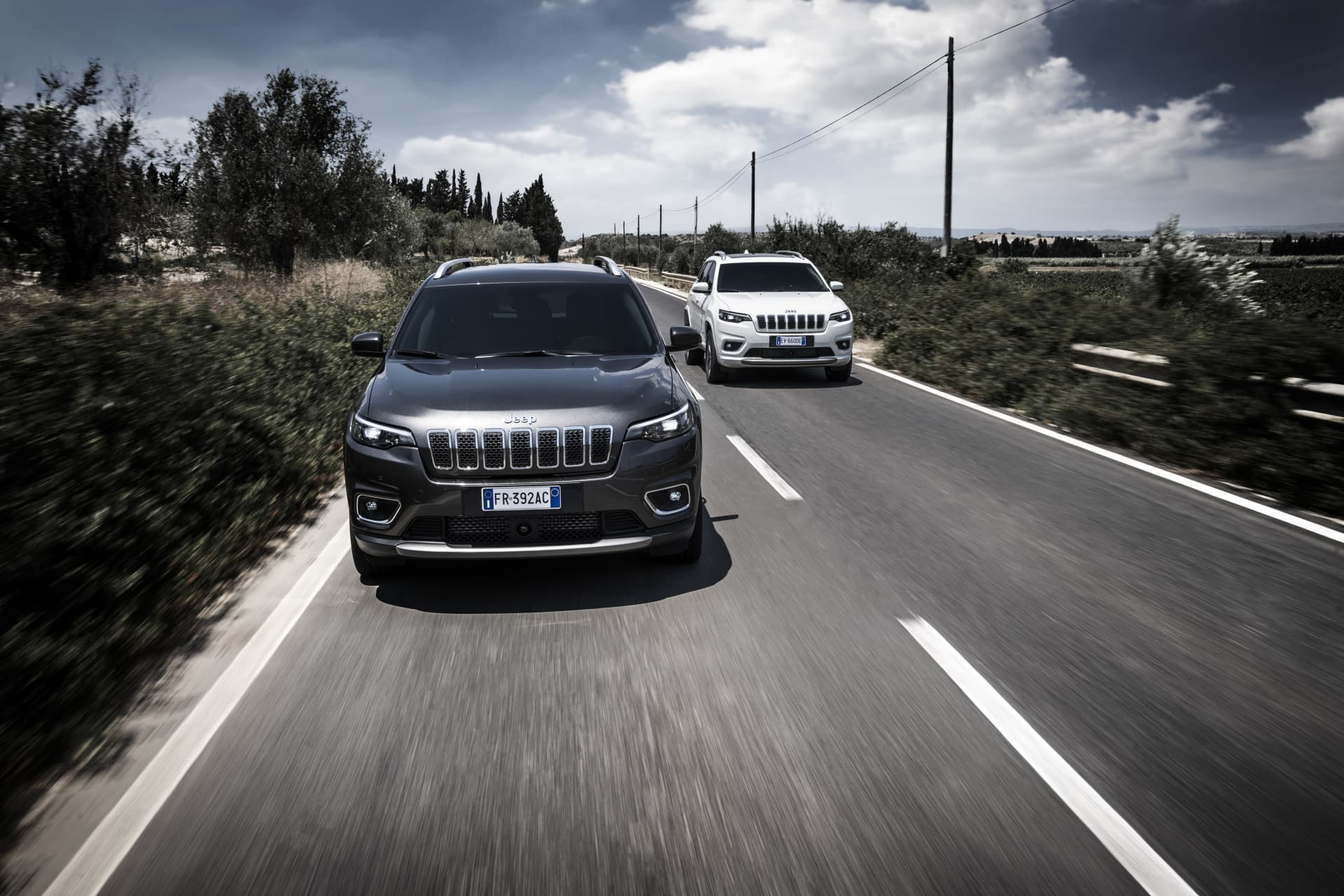 Vista dinámica del Jeep Cherokee en carretera, enfatizando su frontal robusto y diseño lateral.
