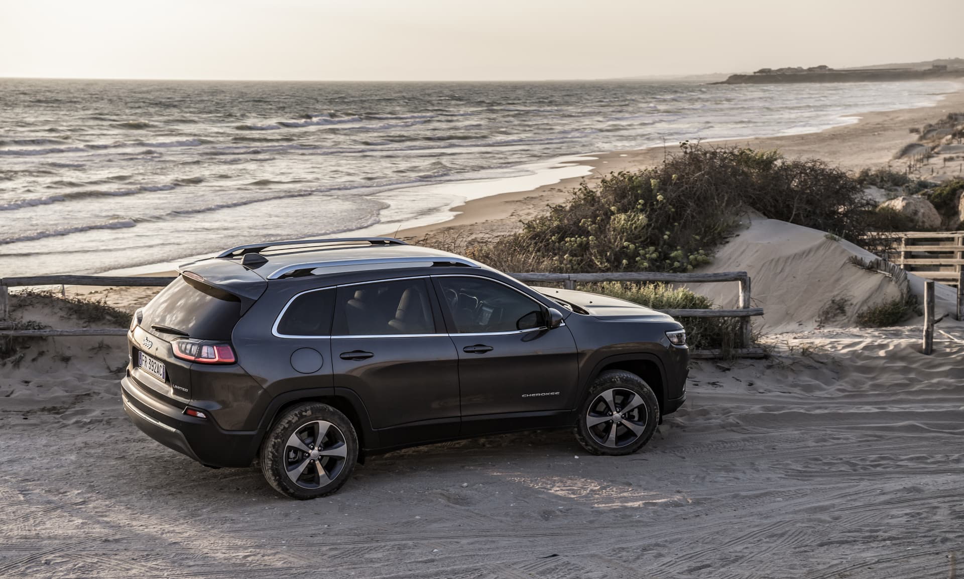 Vista lateral del Jeep Cherokee en un entorno costero.