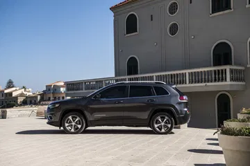 Vista lateral del Jeep Cherokee mostrando el diseño de las llantas y la línea de la carrocería.