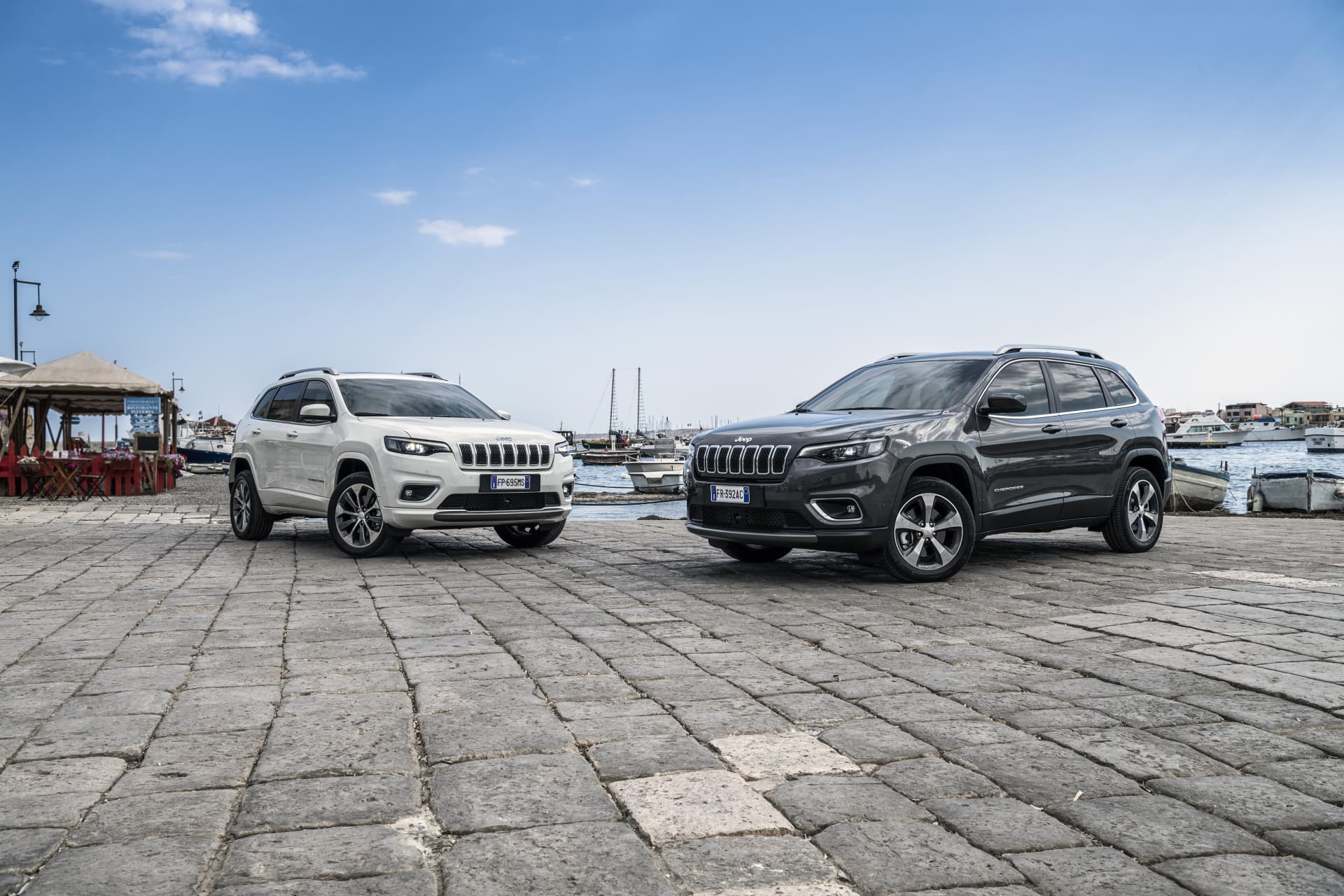 Vista lateral de dos Jeep Cherokee aparcados en un muelle.