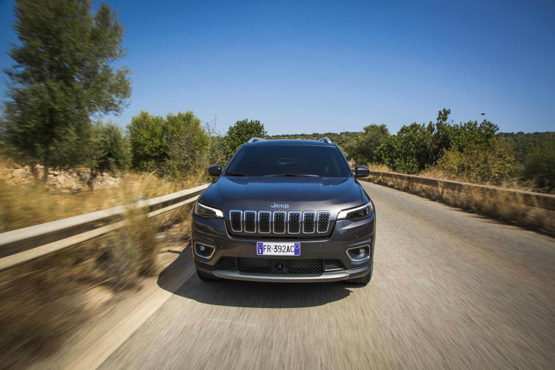Vista frontal del Jeep Cherokee en movimiento por carretera asfaltada