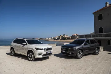 Vista delantera y lateral del Jeep Cherokee en un entorno costero.