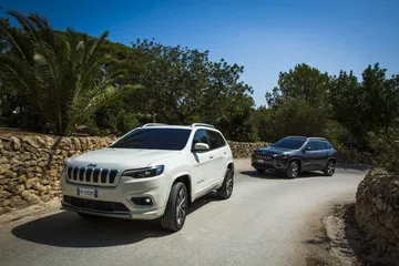 Vista en ángulo del Jeep Cherokee destacando su imponente parrilla frontal.