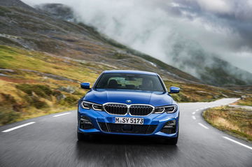 Vista dinámica del BMW Serie 3 avanzando por serpenteante carretera de montaña